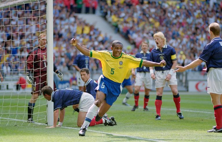 PARIS, FRANCE - JUNE 10: Cesar Sampaio of Brazil celebrates scoring the opening goal of the World Cup as Scotland captain Colin Hendry (2nd r) reacts during the group A game against Scotland at the Stade de France in St Denis, France, Brazil won 2-1. (Photo Shaun Botterill/Allsport/Getty Images)