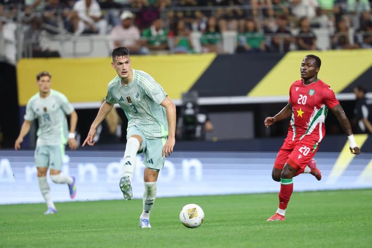 César Montes competes with Gleofilo Vlijter during a 2025 Gold Cup group stage match