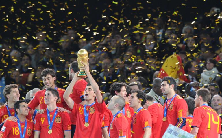 Spain's midfielder Sergio Busquets raises the trophy after the award ceremony following the 2010 FIFA football World Cup between the Netherlands and Spain on July 11, 2010 at Soccer City stadium in Soweto, suburban Johannesburg. Spain won 1-0. NO PUSH TO MOBILE / MOBILE USE SOLELY WITHIN EDITORIAL ARTICLE AFP PHOTO / PEDRO UGARTE (Photo credit should read PEDRO UGARTE/AFP via Getty Images)