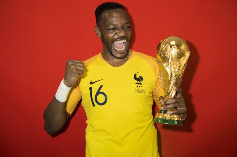 MOSCOW, RUSSIA - JULY 15: Steve Mandanda of France poses with the Champions World Cup trophy after the 2018 FIFA World Cup Russia Final between France and Croatia at Luzhniki Stadium on July 15, 2018 in Moscow, Russia. (Photo by Michael Regan - FIFA/FIFA via Getty Images)